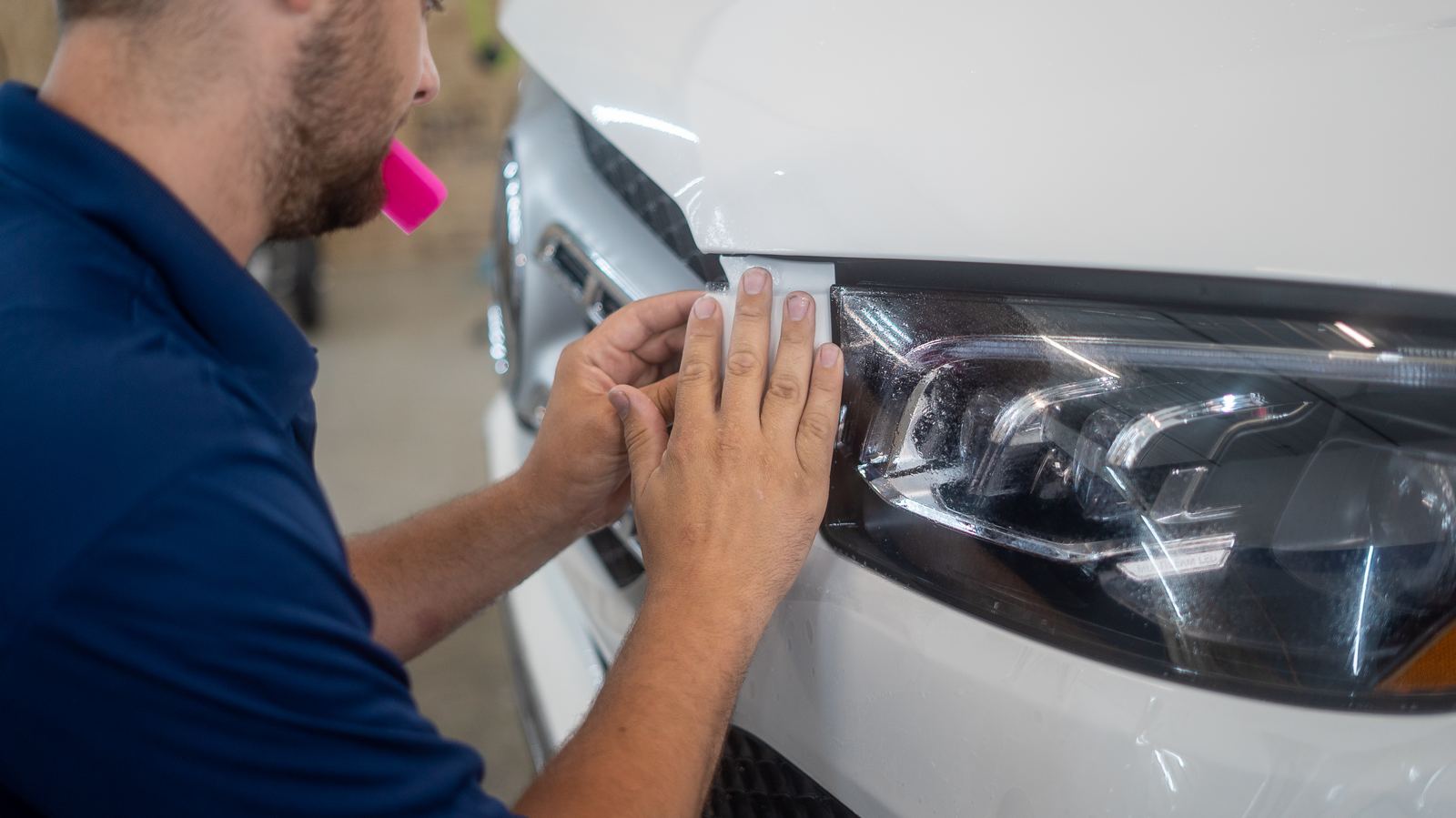 Close-up of PPF being installed on a bumper and headlight